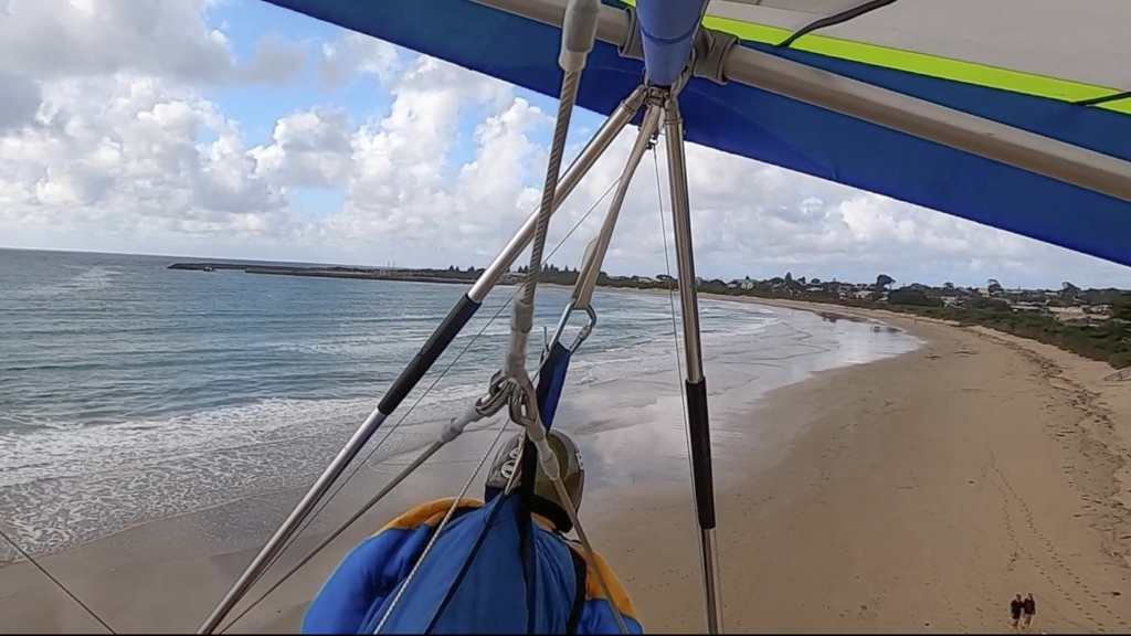 Hang glider on final approach for beach landing